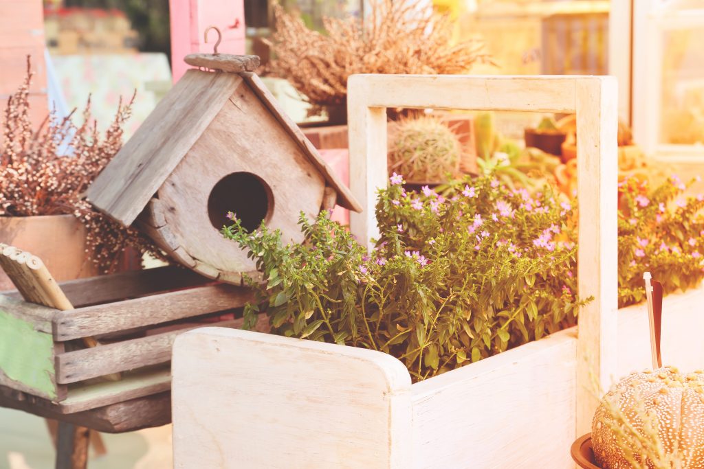 Balkon mit Frühlingspflanzen und Vogelhaus als bienenfreundliche Umgebung für Stadtimkerei